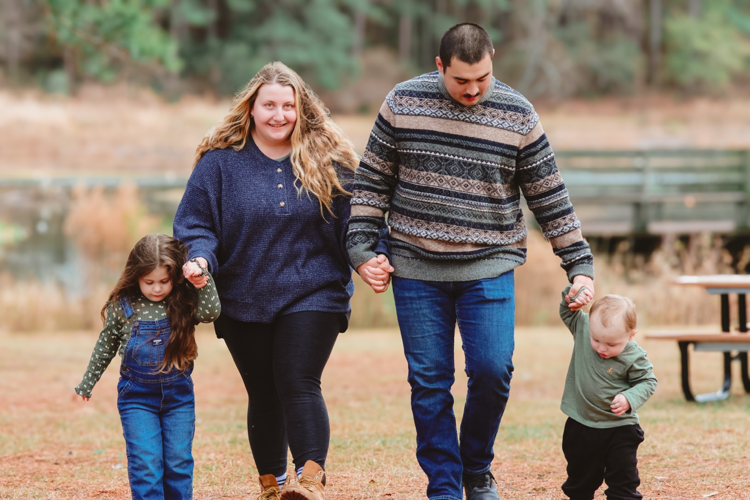 Family of four holding hands while walking outdoors